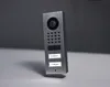 A modern, brushed stainless steel video intercom system with a camera, keypad, and two nameplates is shown against a gradient gray background. Anteprima dell’immagine prodotto