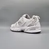 A side view of a white and silver New Balance sneaker against a plain gray background. Podgląd zdjęcia produktu