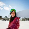A woman in ski gear holding a snowboard. Náhľad obrázku produktu