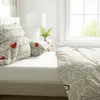 A bedroom scene with a bed made with heart-patterned bedding. Produktbild-Vorschau