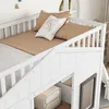 A close-up view of a white wooden bunk bed with pillows and bedding. Produktbild-Vorschau