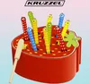 A toy strawberry with colorful worms sticking out, and a magnetic wand. Voir les images du produit
