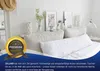 A bed with a long white pillow, decorated with framed pictures and vases on a nightstand. Produktbild-Vorschau