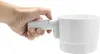 A hand is holding a white kitchen gadget. Produktbild-Vorschau