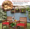 A wooden garden bench and table set with red cushions, set up on a lawn in a garden. Náhled obrázku produktu
