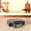 A KRUPS sandwich maker is shown on a countertop with a blurred background of kitchen items. Anteprima dell’immagine prodotto