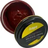 An open jar of brown shoe cream with its lid next to it. Produktbild-Vorschau
