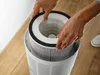 Hands are shown inserting a filter into an air purifier. Produktbild-Vorschau
