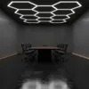 A modern conference room with a hexagonal LED ceiling light fixture and a large conference table with chairs. Podgląd zdjęcia produktu