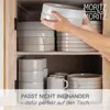 Hands placing plates in a wooden cabinet. Produktbild-Vorschau