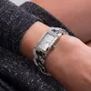 A close-up shot of a woman's wrist wearing a silver Guess watch with a diamond-encrusted band and face. Produktbild-Vorschau