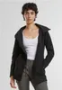 A woman wearing a black jacket and white tank top, standing against a white background. Produktbild-Vorschau