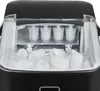Close-up view of the inside of a black ice maker, showing ice cubes being formed and already made ice cubes in the collection bin. Podgląd zdjęcia produktu