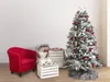 A decorated artificial Christmas tree with a red armchair and wooden crates. Podgląd zdjęcia produktu