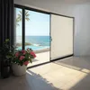 A view from inside a room looking out to a balcony with a swimming pool and the ocean beyond. The product is partially visible on the right side of the image. Náhled obrázku produktu