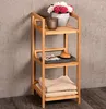 A bamboo shelf unit with decorative items and towels against a concrete wall. Náhled obrázku produktu