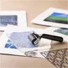 A close-up of a gel printing kit with a roller, a clear gel plate, and some printed papers. Produktbild-Vorschau