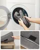 Collage showing a gray fabric item being placed into a washing machine, a close-up of the item on a wooden shelf, and a close-up of a zipper and velcro on the item. Náhled obrázku produktu