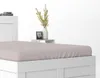 A close-up view of a white bed frame with a pink fitted sheet. Náhled obrázku produktu