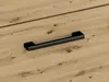 A close-up shot of a black handle on a wooden surface. Náhled obrázku produktu