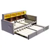 A gray sofa bed with its mattress frames extended, showing the storage shelves at the headboard. Voir les images du produit