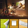 A family is watching a movie projected onto a screen in a dimly lit room, with decorative lights on the floor. Produktbild-Vorschau