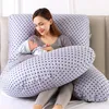 A woman is holding a baby while resting on a large, star-patterned pregnancy pillow. Náhled obrázku produktu