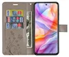 A gray flip case for a smartphone, open to reveal card slots and a bill compartment, with the phone displaying a colorful abstract wallpaper. Produktbild-Vorschau