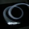 A bundle of white fiber optic strands is coiled on a black surface, with the ends illuminated. Produktbild-Vorschau