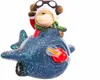 A close-up of a Christmas ornament featuring a monkey dressed as a pilot riding in a blue airplane. Produktbild-Vorschau