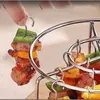 A hand is shown holding a skewer with meat and vegetables, about to place it into a metal grill rack. Náhľad obrázku produktu