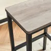 Close-up of the corner of a bar stool with a wood-grain top and black metal legs. Produktbild-Vorschau