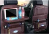 A car interior showing a brown leather seat organizer with various items stored in it, including a tablet, drinks, and tissues. Podgląd zdjęcia produktu
