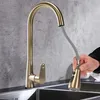 A hand is shown holding the spray head of a gold kitchen faucet over a sink. Náhľad obrázku produktu