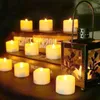 A collection of LED tea lights and a lantern are arranged on a surface, possibly a table or shelf, with books in the background. Produktbild-Vorschau