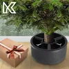 A Christmas tree stand with a gift box next to it. Náhľad obrázku produktu