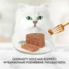 A white Persian cat looks at a fork holding a piece of cat food, with a serving of cat food on a plate in front of it. Podgląd zdjęcia produktu