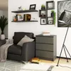 A living room scene with a chest of drawers, a sofa, shelves, and a floor lamp. Produktbild-Vorschau