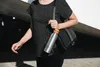 A person walking with a water bottle and a purse. Produktbild-Vorschau