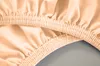 A close-up view of a peach-colored fitted sheet with elasticized edges. Produktbild-Vorschau