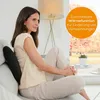 A woman is sitting on a couch with a back support cushion. Produktbild-Vorschau