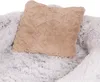 A close-up view of a fluffy pet bed with a tan pillow on top. Produktbild-Vorschau