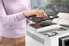 A person is adding coffee beans to a coffee machine. Produktbild-Vorschau
