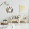 A living room scene with a vintage-style wall clock, a sofa with decorative pillows, and a floor lamp. Anteprima dell’immagine prodotto