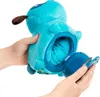 Hands holding a blue plush puppy toy with a removable blue plastic part. Náhled obrázku produktu