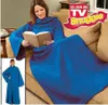 A woman is sitting on a couch reading a book while wrapped in a blue Snuggie. A smaller inset image shows a person standing in a blue Snuggie. Náhľad obrázku produktu
