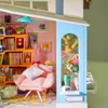 A miniature dollhouse room with a pink armchair, bookshelf, and decorative items. Anteprima dell’immagine prodotto