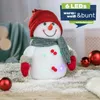 A decorative snowman figurine with LED lights, surrounded by artificial snow and Christmas ornaments. Produktbild-Vorschau