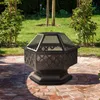 A fire pit sits on a brick patio in a garden setting. Anteprima dell’immagine prodotto