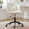 A beige office chair with a scalloped back and a small pillow is shown in a room with a white desk and a vase of flowers.